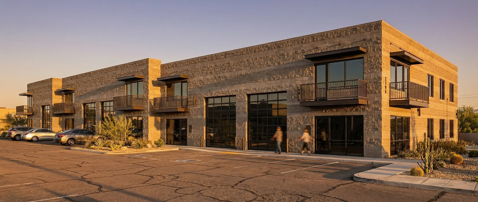 Exterior rendering of Lakeview Executive Lofts showing charcoal masonry construction, overhead doors, and mezzanine balconies