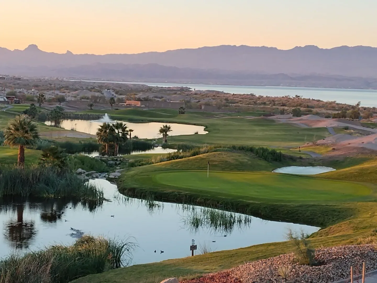 Aerial view of a green and lake at Iron Wolf Golf Club in Lake Havasu City