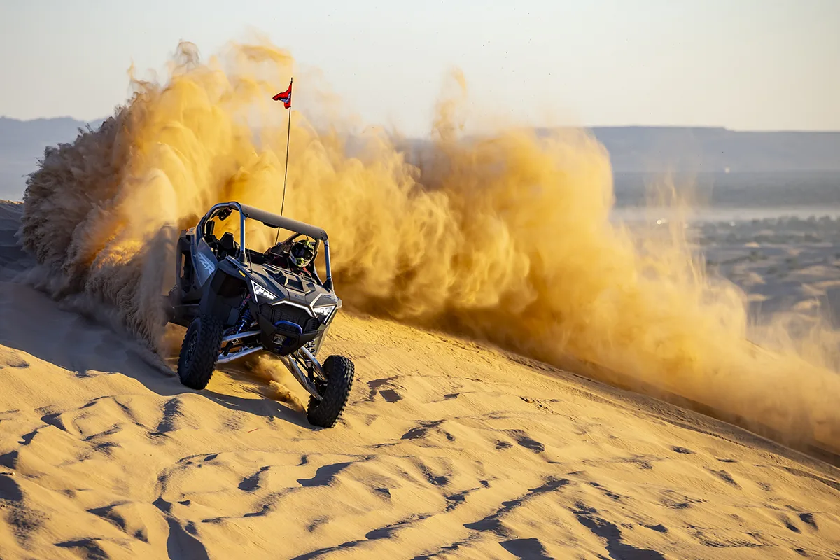A Can-Am RZR side-by-side kicking up sand while off-roading near Lake Havasu